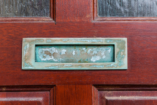 Old retro mailbox on the wooden doors. Hole on the wooden doors for mail.