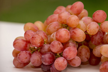 Red grapes on green and white background