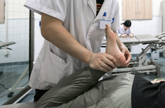 The doctor is rehabilitating the patient's legs