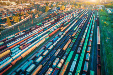 Fototapeta na wymiar Aerial view of freight trains. Colorful cargo wagons on railway station. Wagons with goods on railroad. Heavy industry. Industrial landscape with train, railway platfform at sunset. Top view. Depot