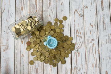jar of coins with analog alarm clock on vintage wooden table.Financial and investment concept.