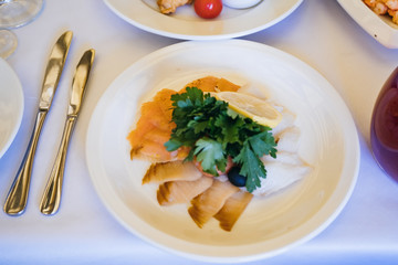 food in a plate on the festive table. table setting at the banquet. cold appetizer and salad for business lunch close up