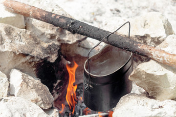 USSR army pot of water hanging on a stick over a fire