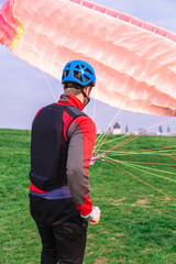 Paraglider landed after jump and raises parachute