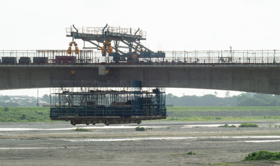 川を渡る線路の建設現場と重機