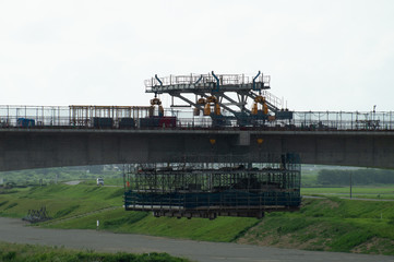 川を渡る線路の建設現場と重機