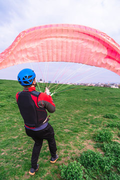 Man with paraplane starting to fly from hill top