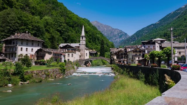 Time lapse view of small village with a Roman bridge over the river Lys in the Italian Alps in Aosta valley