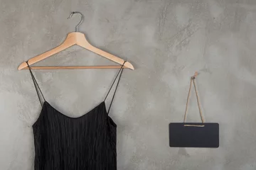 Fotobehang Fashion and shopping concept - blank blackboard and beautiful little black dress on a hanger © veranoverde