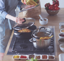 Beautiful young woman cooking in kitchen at home.