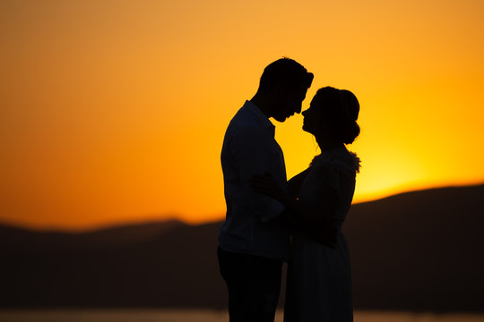 silhouette of couple kissing at sunset