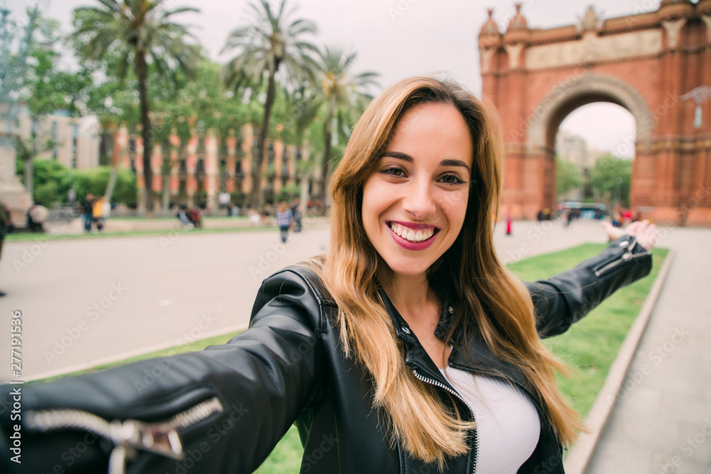 Wall mural get ready to exciting weekend at barcelona. smiling young woman tourist taking selfie on street