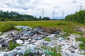 The unauthorized dump of garbage among the wild nature near the industrial and living areas
