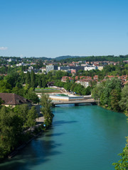 Fototapeta na wymiar Bern, Switzerland - Jun 1st 2019: .The Aare river flows around three sides of the city of Bern. With its crystal-clear turquoise water