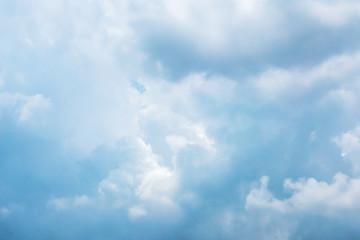 The white clouds in the light pastel blue sky in the afternoon.