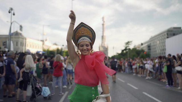 A woman waves a gay rainbow flag at an LGBT summer gay pride parade