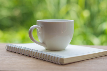 Coffee espresso on wood table nature background in garden,warm tone