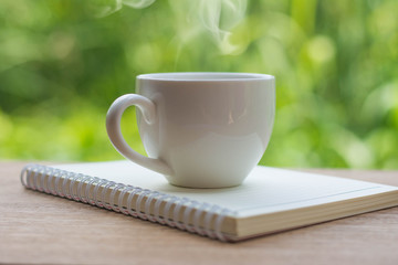 Coffee espresso on wood table nature background in garden,warm tone