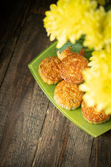 Mooncakes, yellow chrysanthemum flowers wooden background with copy space. Chinese mid-autumn festival food.
