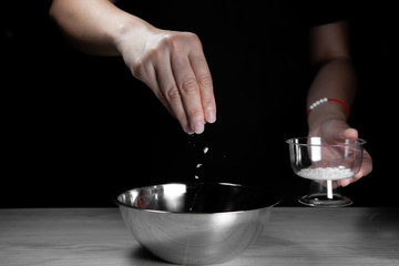 Woman chef sprinkles salt and seasoning for marinated fillet by condiment on a wooden table in the kitchen . Hand sprinkles salt for Preparing healthy food Cooking menu at Home .