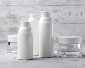 Set of cosmetic cream bottles on gray background.