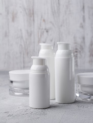 Set of cosmetic cream bottles on gray background.