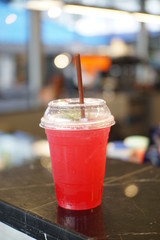 Italian soda with lime in plastic glass on marble stone bar at loft style shop. Soda red water with lime,Salak Lemon Soda,Sweet water,Cafe menu.