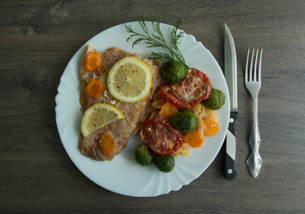 Baked white fish with lemon, cabbage, carrots, tomatoes, potatoes