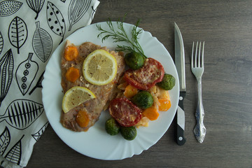 Baked white fish with lemon, cabbage, carrots, tomatoes, potatoes