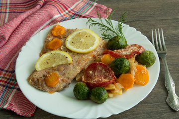 Baked white fish with lemon, cabbage, carrots, tomatoes, potatoes