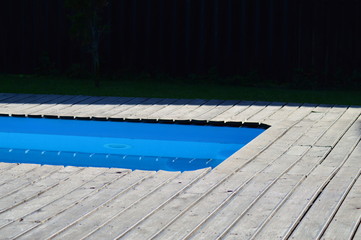 blue swimming pool with sun loungers