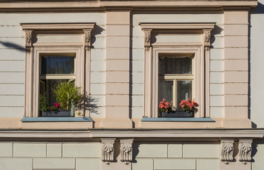 detail of beige facade of old prague tenement house Windows with flower boxes