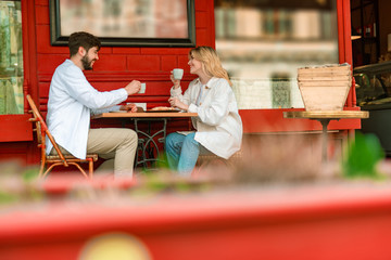 Happy young couple having date in outdoor cafe