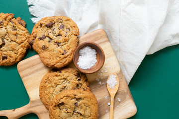 Homemade Salted Chocolate Chip Cookies on Colorful Green Background, Styled Flat Lay Dessert 