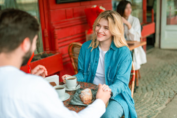 Joyful bearded man holding hand of his charming girlfriend