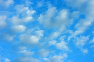 Blue sky background and a lot of white air clouds on a sunny summer day