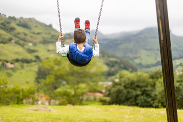 Swinging child on the middle of a field