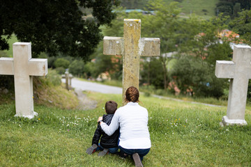 Mother and son in front of a cross