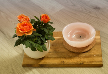 Obraz na płótnie Canvas Orange roses on wooden board background in pot.