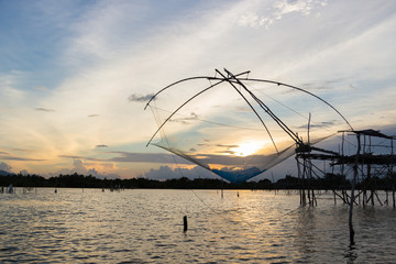 Fototapeta na wymiar Silhouette of square dip nets with sunrise sky background, livelihoods of fishermen at Pakpra, Phatthalung in Thailand