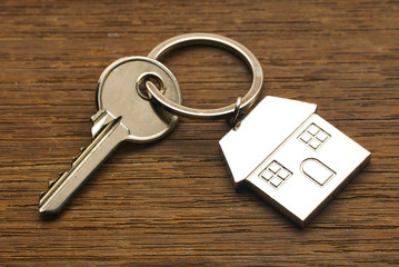 Topview key with house key chain on wood table.