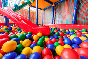 Colored plastic balls in pool of game room. Swimming pool for fun and jumping in colored plastic balls