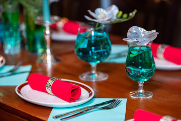 table with tableware at the bar is beautifully set with red candles and for a night celebration party.
