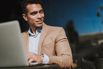 Cheerful elegant man with notebook near the building