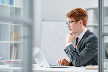 Young serious analyst concentrating upon intellectual work