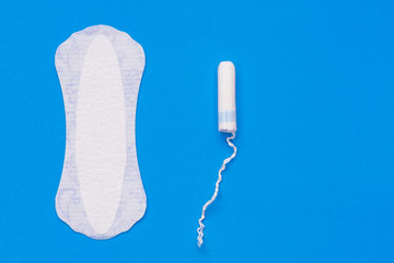 Fototapeta na wymiar Woman hygiene protection. Cotton tampons and sanitary pads on blue background top view.