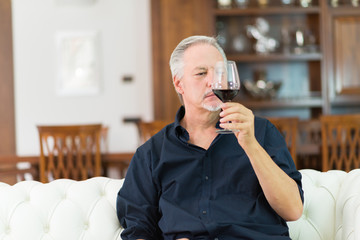 Mature man drinking a glass of red wine