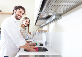 Young couple doing dishes in the kitchen