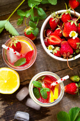 Fresh Strawberry lemonade on rustic wooden table. Top view flat lay background.