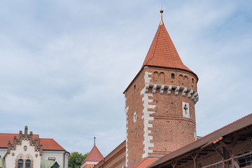 Fototapeta na wymiar Medieval red brick castle defense watchtower against blue sky.
